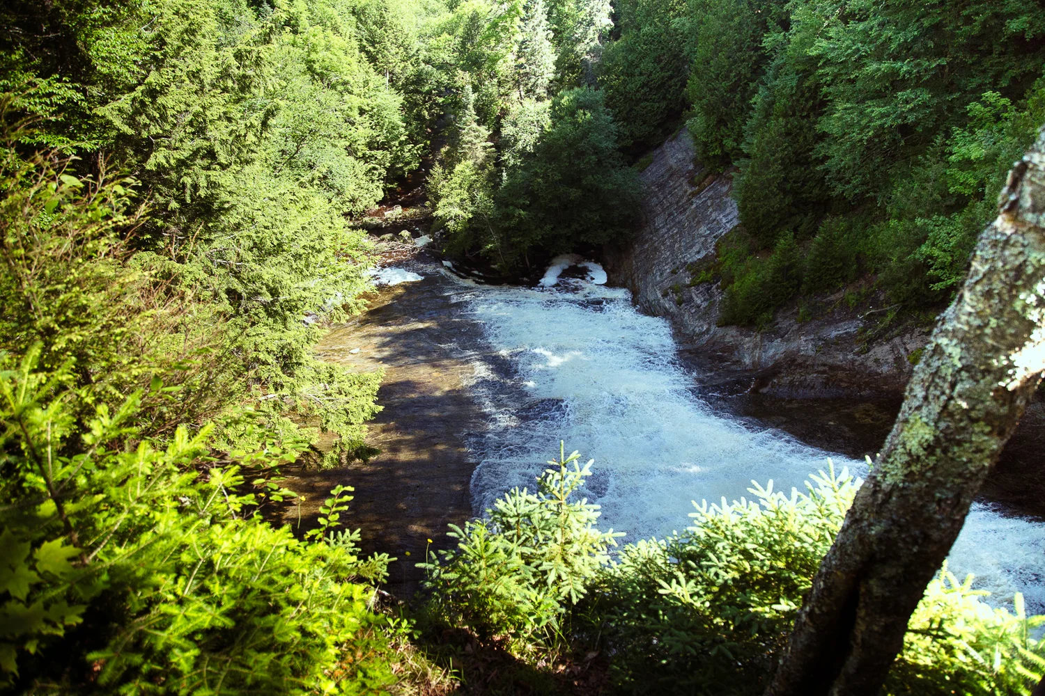 Laughing Whitefish Falls slide waterfall through forested gorge