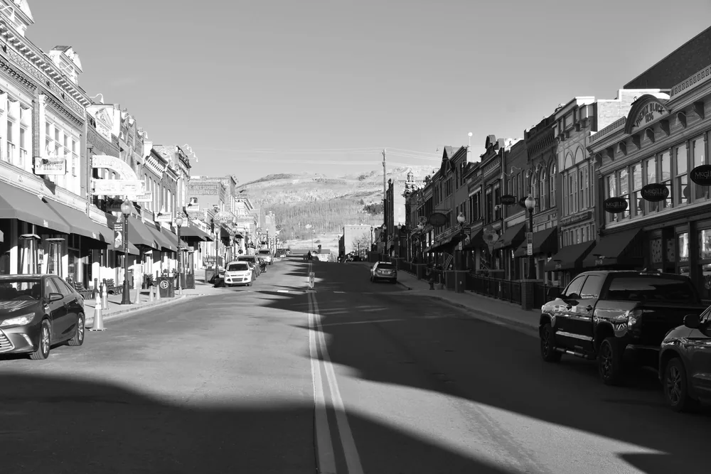 Black and white photo of a historic main street with vintage buildings and cars