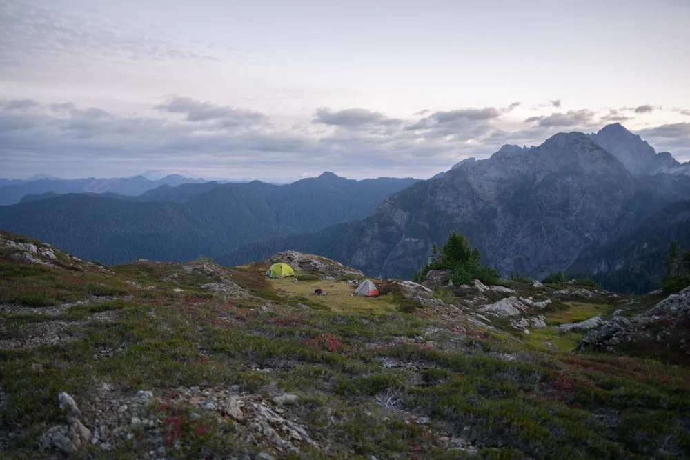 Peaceful campsite with tents near mountains in Washington's wilderness at sunrise