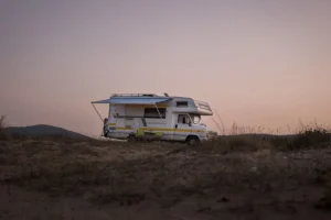 A serene view of an RV parked amidst nature during sunset, capturing a travel adventure
