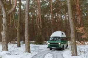Vintage camper van parked in a snowy forest