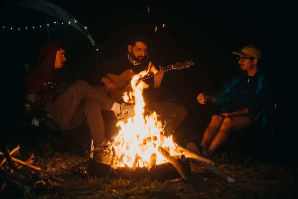 Friends enjoy a musical campfire evening in Natividade da Serra, São Paulo, Brazil